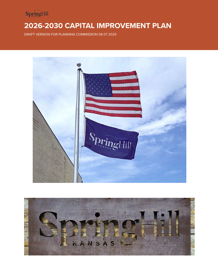 American flag atop the Spring Hill city flag and Spring Hill Kansas Logo on a monument.