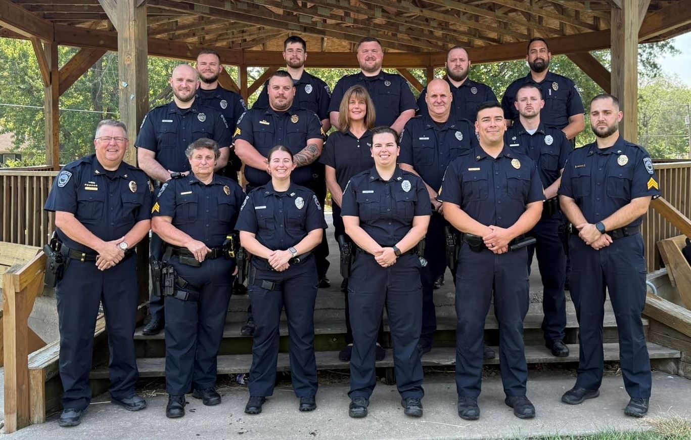 Spring Hill Police Department officers dressed in uniform pose under a gazebo.