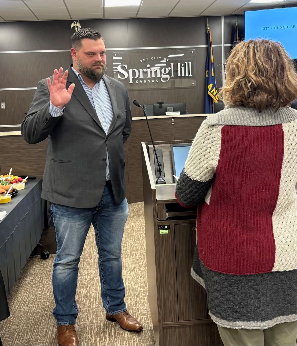 A woman swears in a man inside a City Council meeting.